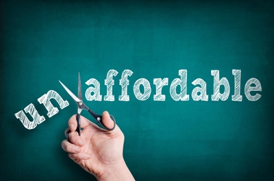 A hand with scissors that is cutting the word Affordable from Unaffordable. Concept debunking domaining myths.