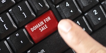 Red keyboard button with the phrase "Domain For Sale". Buying domains for profit concept.