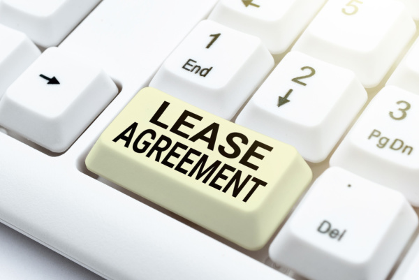 The phrase "Lease Agreement" is displayed on a green laptop button. Lease domain name concept.