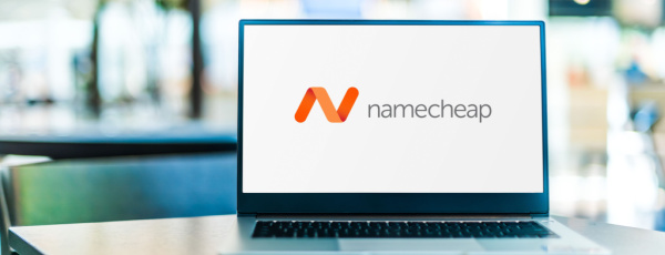 A laptop computer displaying the logo of Namecheap, which provides domain name registration and web hosting. Common Domain Name Questions, concept.