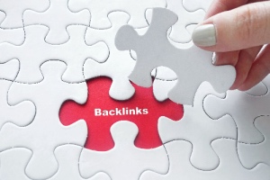 A person's hand places the final jigsaw piece labeled 'Backlinks.' Concept, quality backlinks.